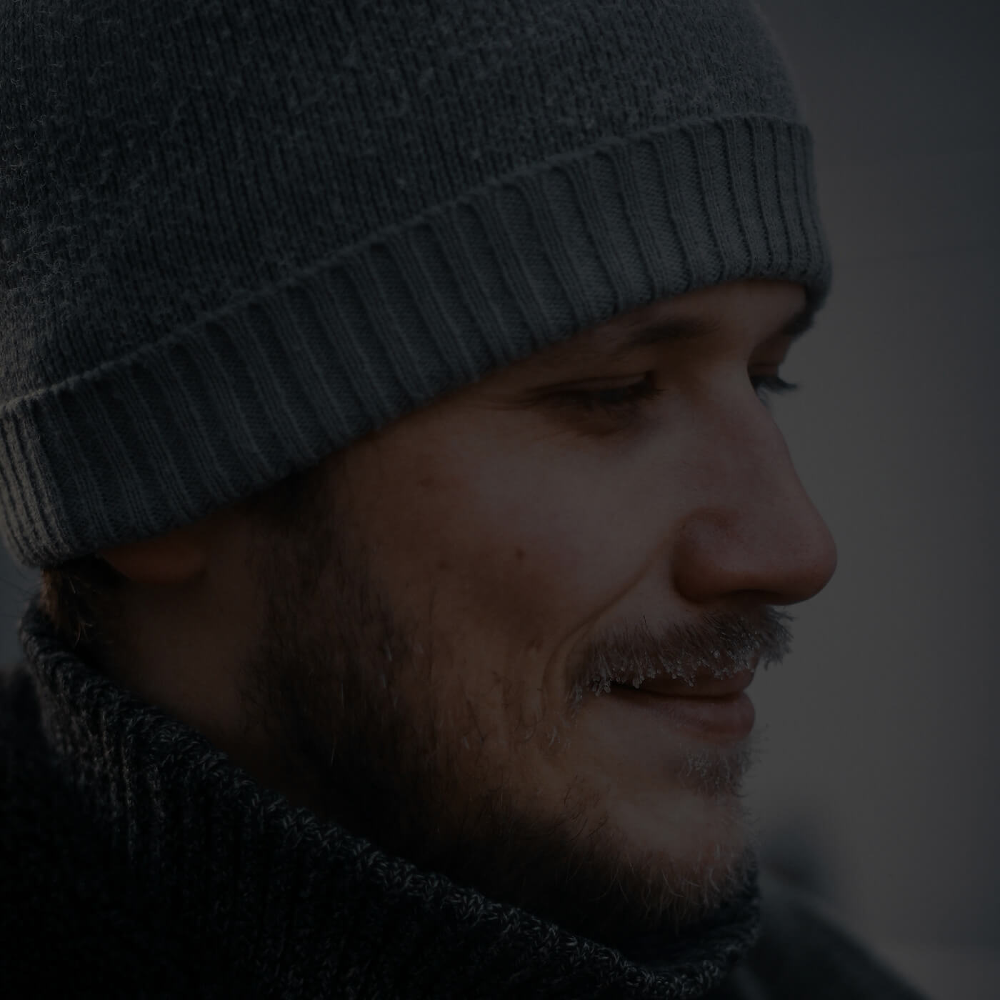 Mann mit Bart trägt Wollmütze aus Alpakawolle draussen im Winter