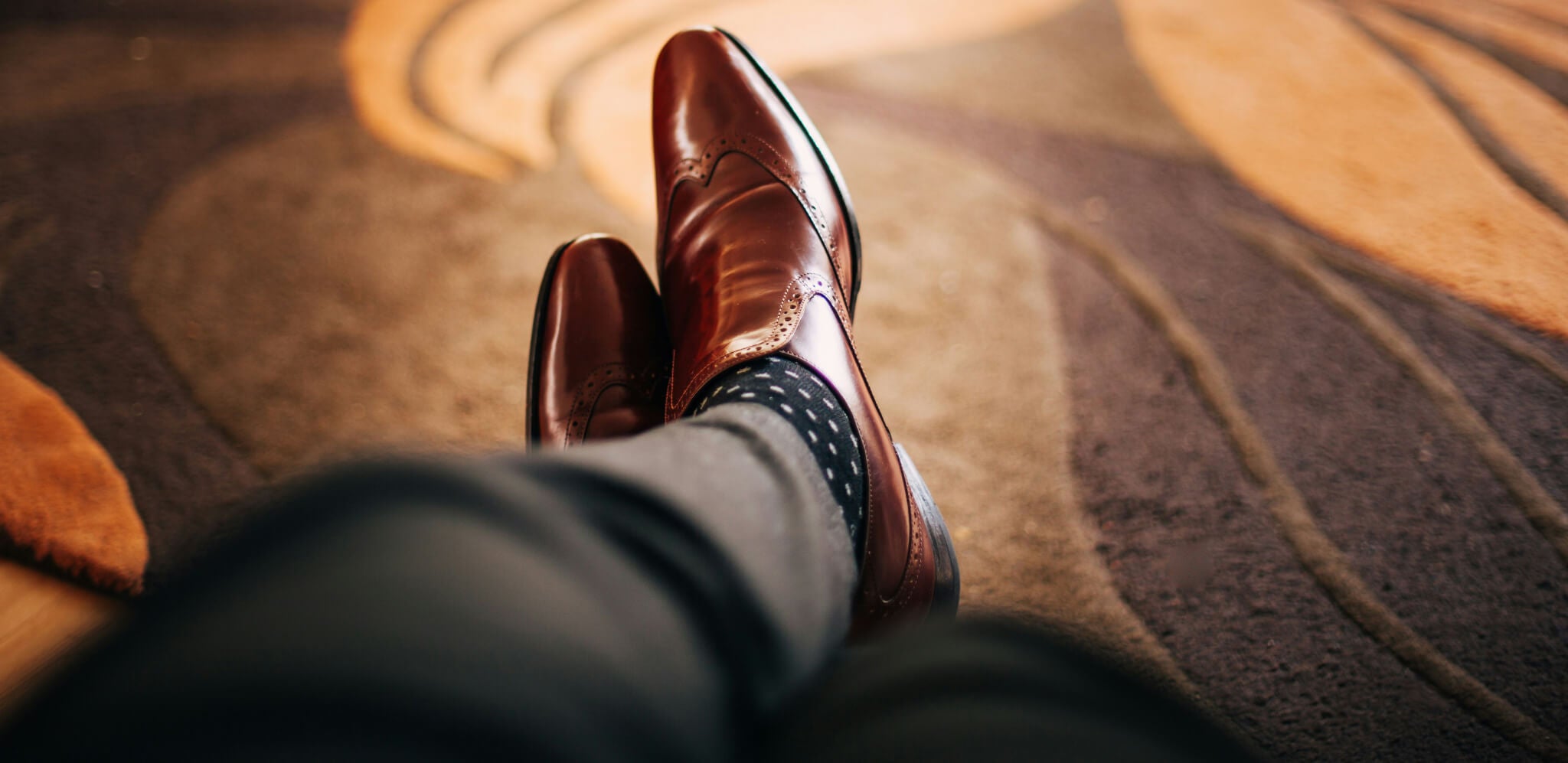 Mann in Anzugshose und eleganten Schuhen trägt Alpaka Socken mit Punkten