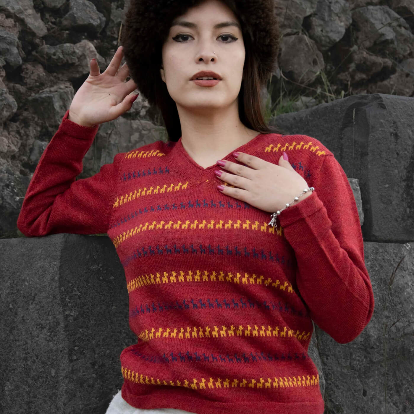 Alpaka Pullover für Damen mit niedlichem Alpaka Muster, getragen von peruanischem Model für Steinkulisse in Cusco