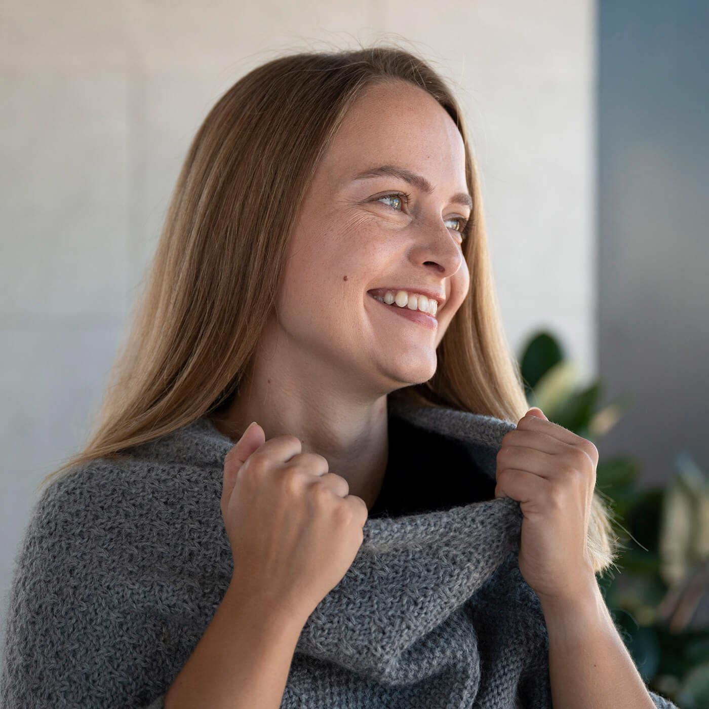 Frau fasst sich an den Kragen ihres weichen Naira Alpaka Strickponchos von Alpakin