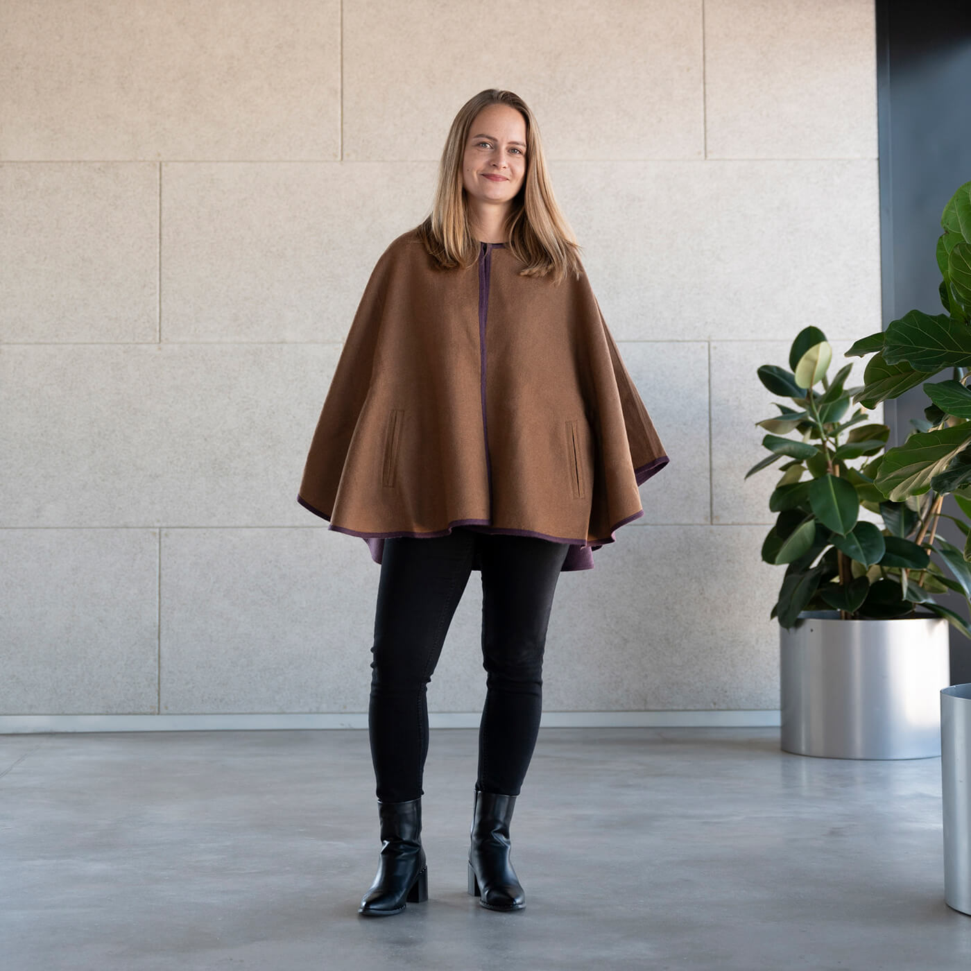 Blondes Model trägt den eleganten Alpaka Poncho Mantel Oro in gold von Alpakin