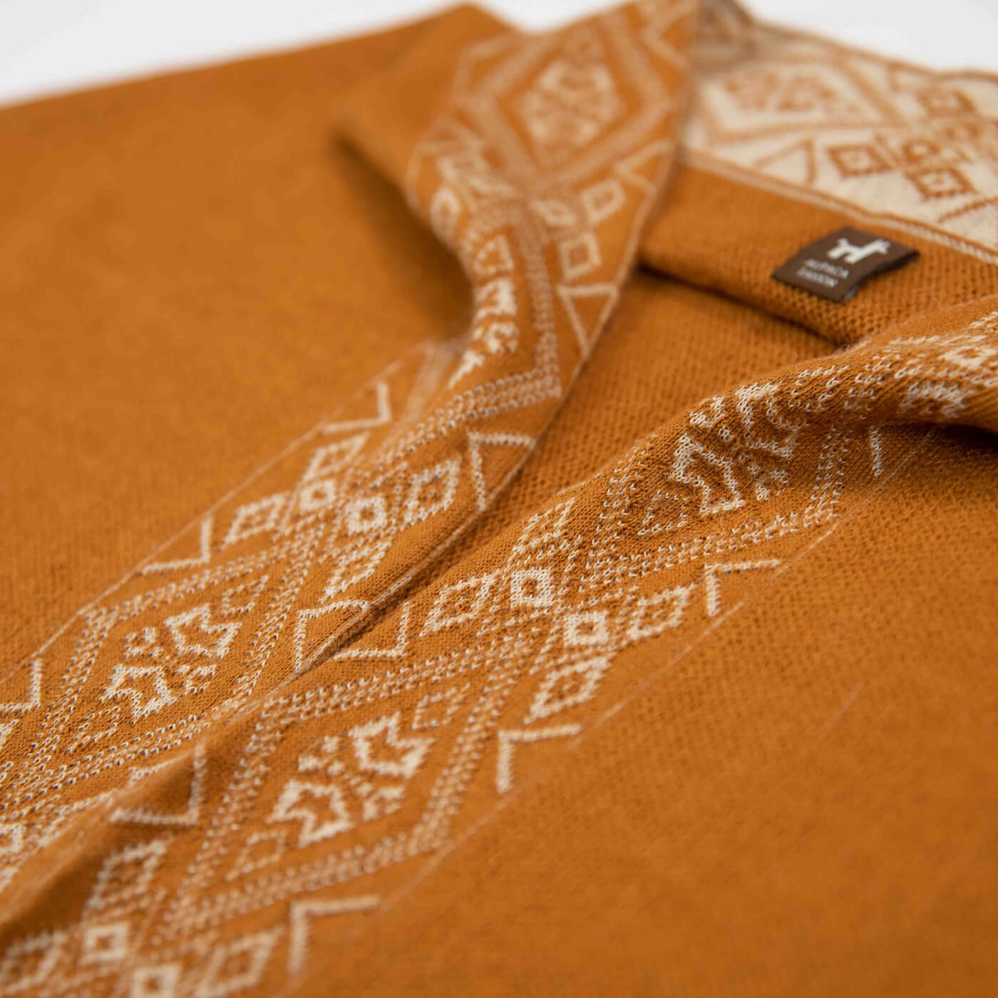 Nahaufnahme feines Textil des Flor Alpaka Poncho Schals in Farbe Kamel