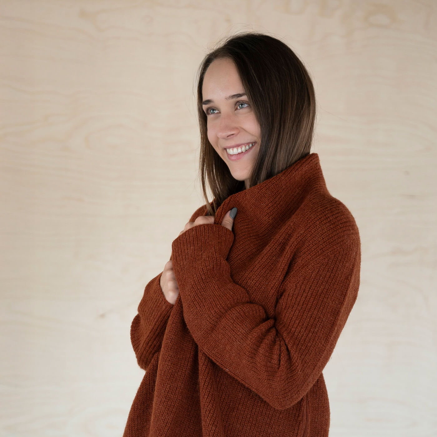 Frau seitlich trägt den warmen Mira Alpaka Cardigan in dunkelorange, gefertigt aus 100% wärmster Babyalpaka Wolle