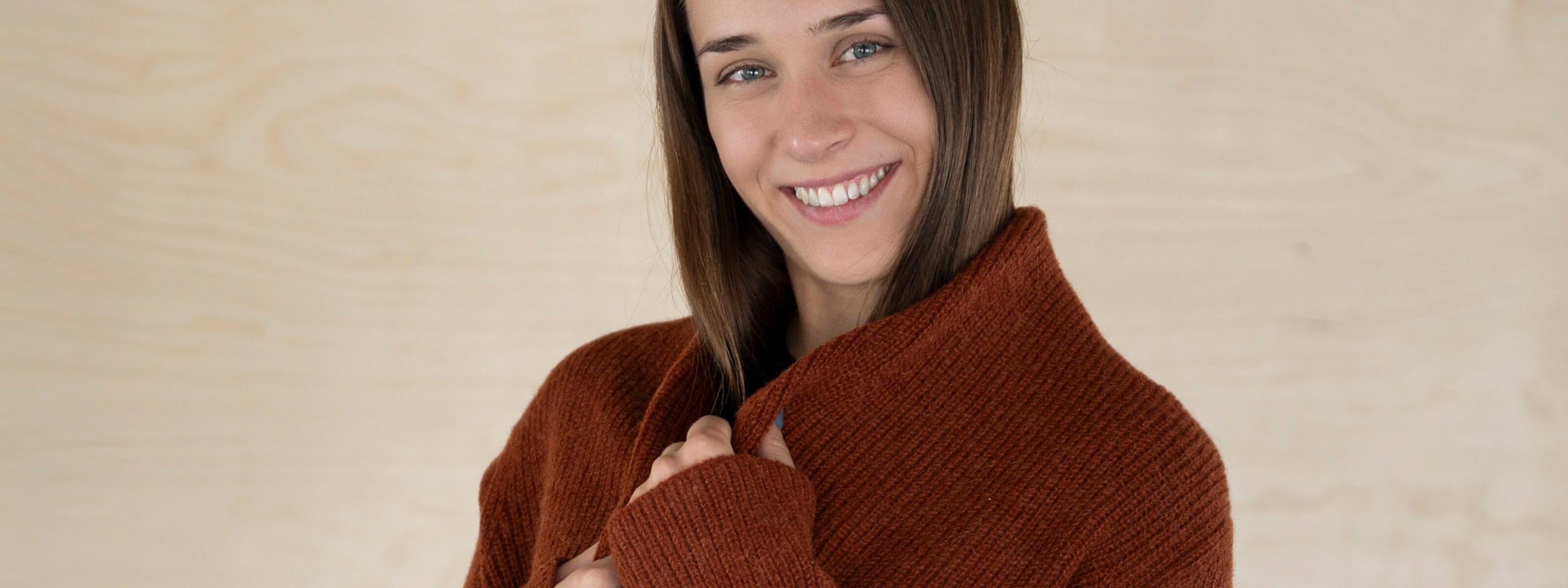 Sanftes Textil des Mira Alpaka Cardigans in dunkelorange, getragen von lächelndem Model