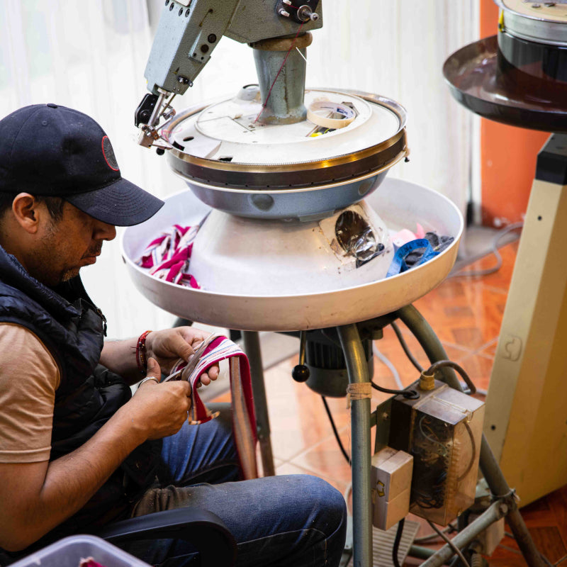 Schneider Alex aus Peru arbeitet mit Schere an Textil