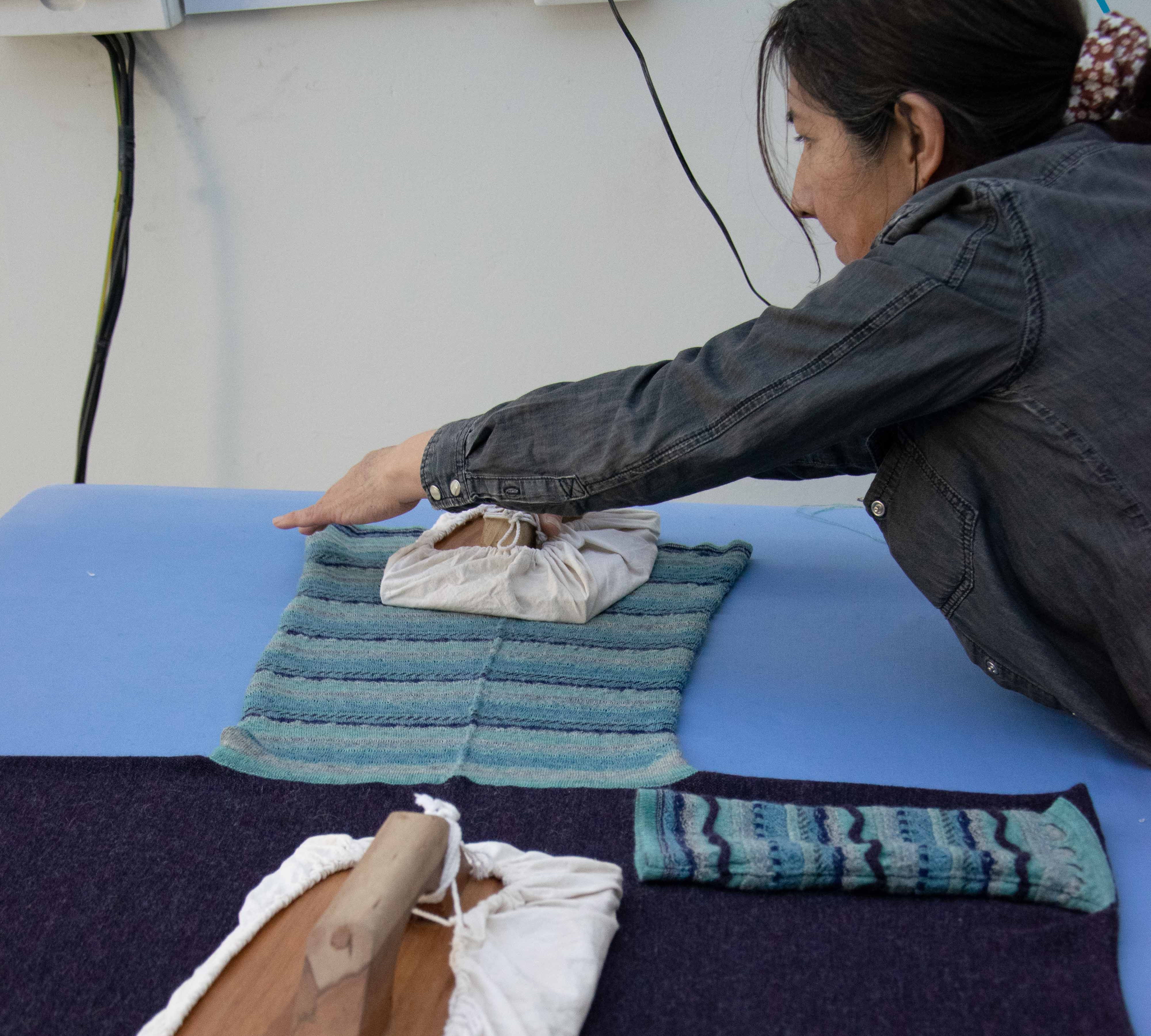 Amanda beim Bügeln von Alpaka Kleidung als letzter Schritt in der Fertigung