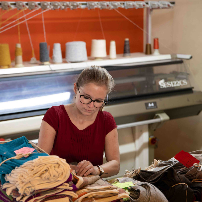 Alpakin Gründerin Carolin Rebhan beim Sortieren von Kleidungsstücken in der Alpakin Manufaktur in Peru