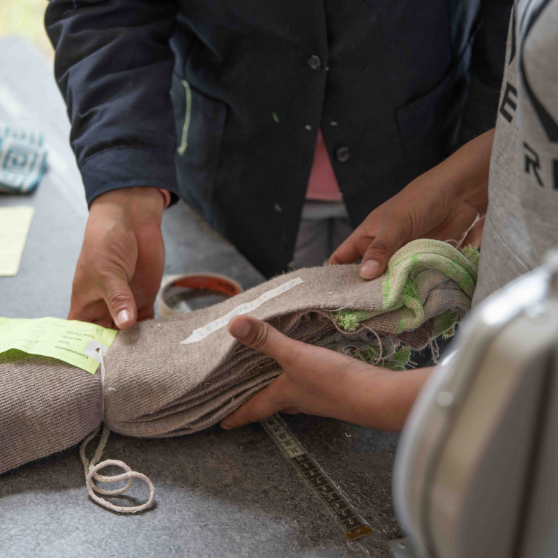 Hände mit Stoffstücken für die Fertigung von Alpaka Kleidung und Accessoires