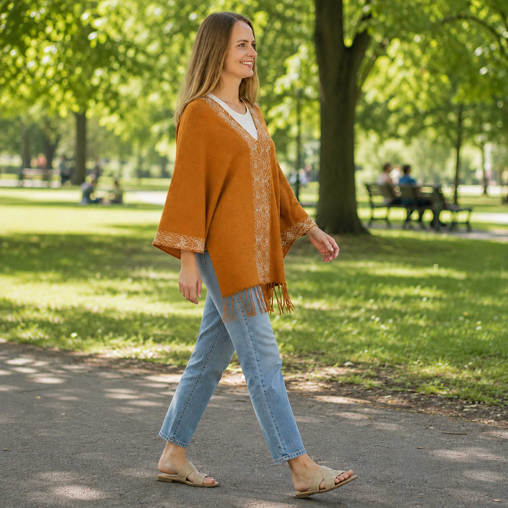 Frau läuft mit Sommer Poncho durch einen grünen Park