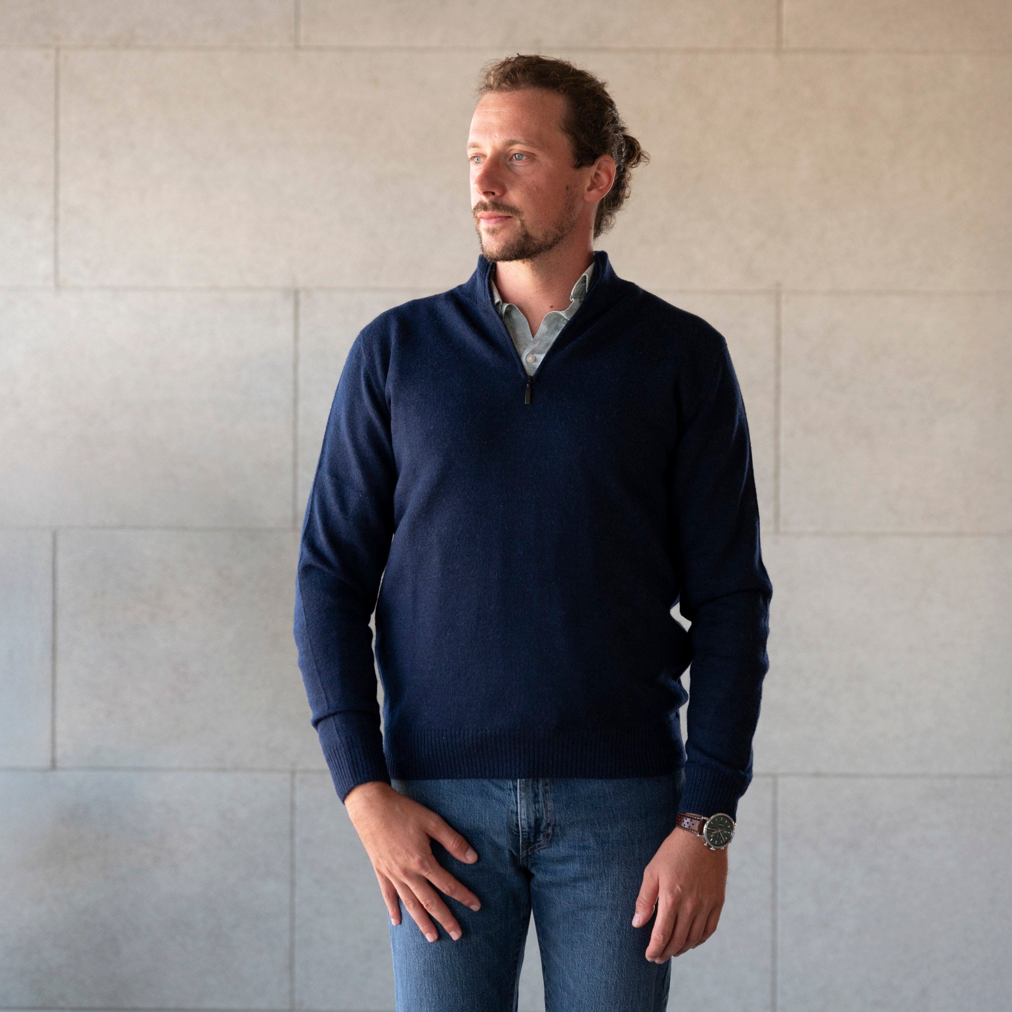 Mann mit Zopf trägt den Alpaka Troyer von Alpakin in dunkelblau aus 100% Babyalpaka