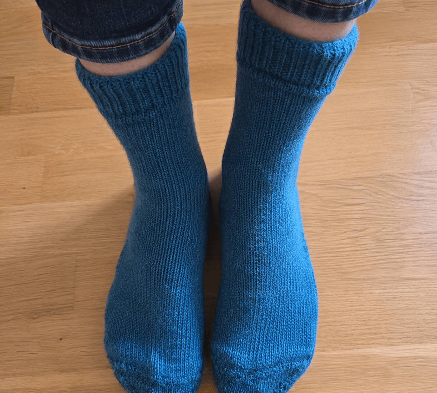Alpakin Kundin trägt die wärmsten Alpaka Socken in dunkeltürkis und fotografiert diese aus ihrer Perspektive von oben