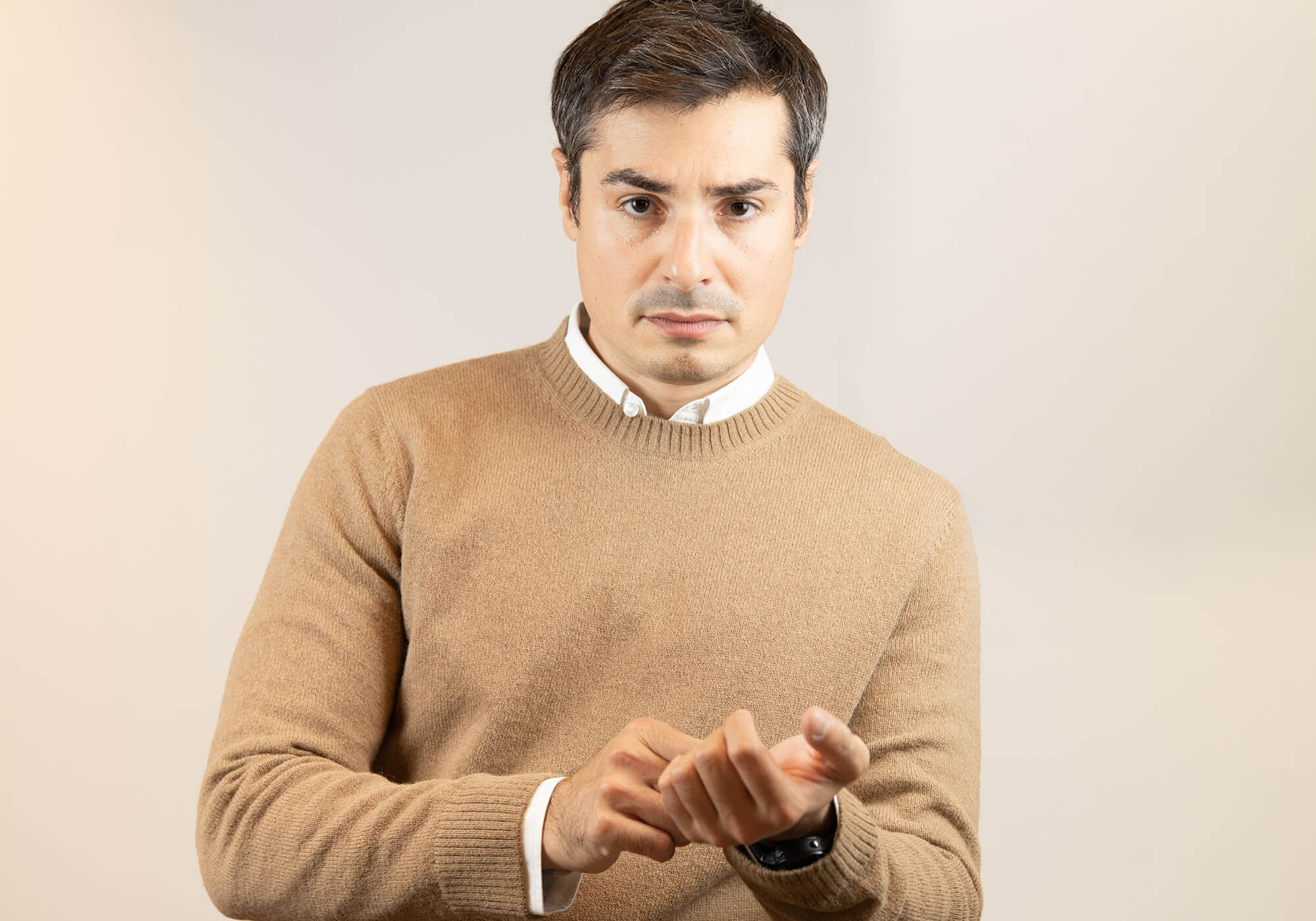 Mann mit Naturfarbe Alpaka Pullover blickt frontal selbstbewusst in die Kamera
