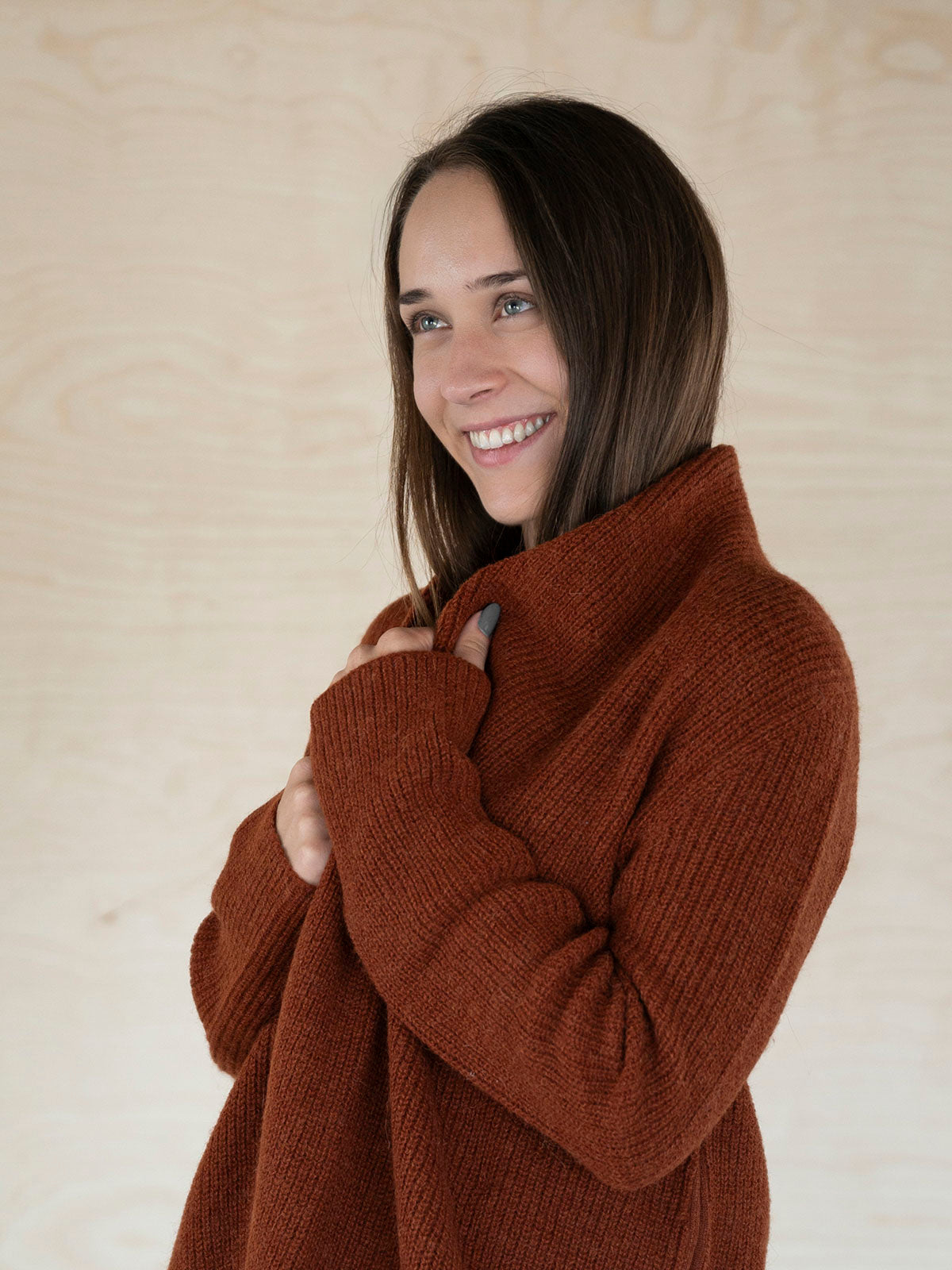 Sanftes Textil des Mira Alpaka Cardigans in dunkelorange, getragen von lächelndem Model - Mobile Version