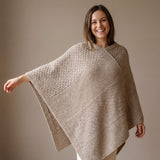 Frau frontal mit Naira Alpaka Strickponcho in Naturfarbe hellbraun