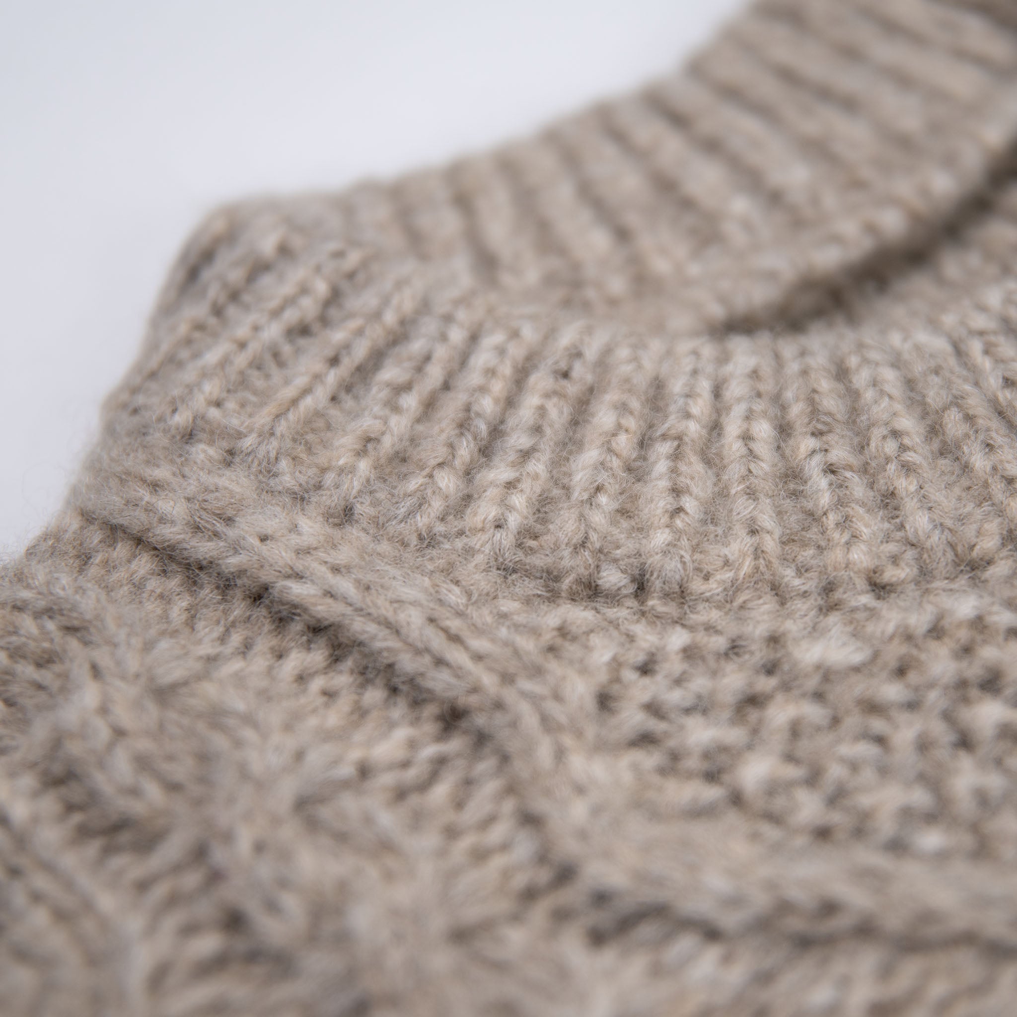 Ausschnitt des Alpaka Wollpullovers mit Zopfmuster in beige