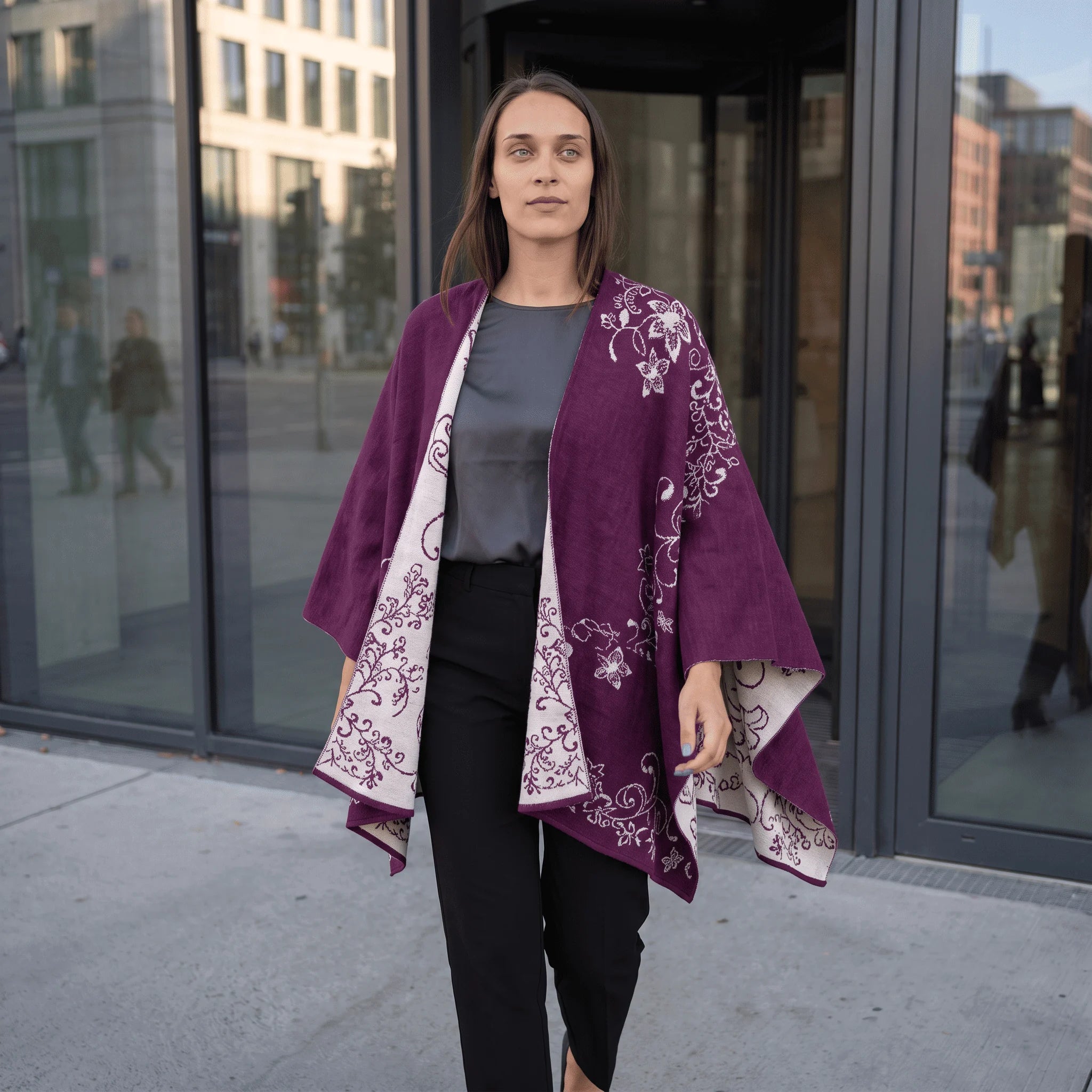 Frau laufend mit dem Alpaka Wendeponcho Tamaya, sodass man den schönen Fall des eleganten Ponchos sieht